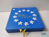 a close up of a blue box with white flowers on it