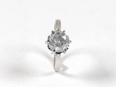 gros plan d'une bague en diamant sur une surface blanche