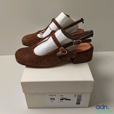 pair of brown and white shoes sitting on top of a white box