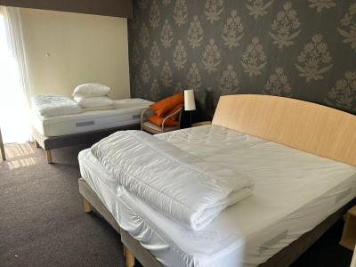 deux lits dans une chambre, avec un mur tapissé derrière eux