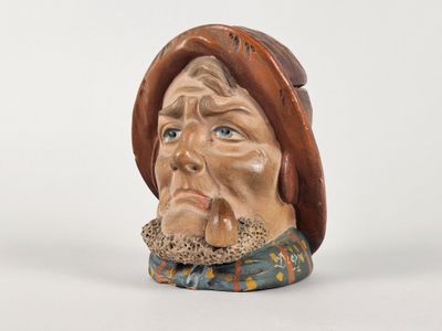 une figurine en céramique représentant un homme coiffé d'un chapeau