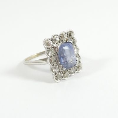 a close up of a blue sapphire and diamond ring on a white background
