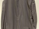 the back of a gray jacket is hanging on a hanger