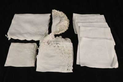 several pieces of white cloth with lace on them on a black background
