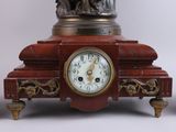 a clock that has a statue on top of it
