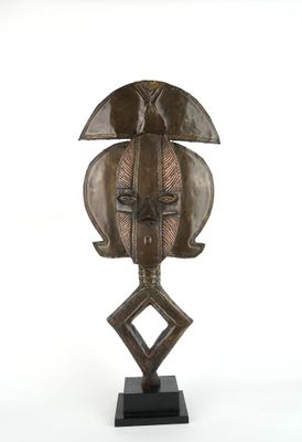 an image of a wooden sculpture of a face on a stand