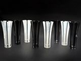 six vases noirs et blancs sont alignés sur une surface noire