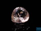 a close up of a pink diamond on a black surface