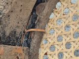 a close up of a wooden chair with a woven seat