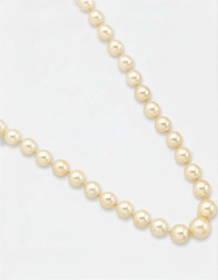 gros plan d'un collier de perles sur une surface blanche