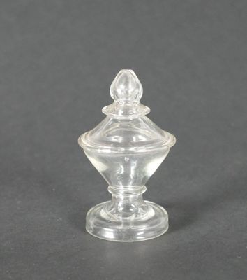 un bocal en verre transparent muni d'un couvercle, posé sur une surface noire