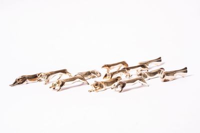 trois figurines en argent représentant des chevaux au galop sur un fond blanc