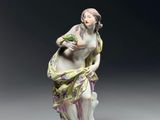 une figurine ancienne représentant une femme tenant un panier