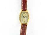 une photo d'une montre-bracelet avec un boîtier en or et un bracelet en cuir marron