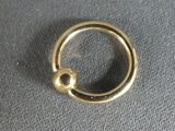 a close up of a gold ring on a gray surface
