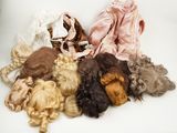 de nombreuses perruques de différentes couleurs disposées sur une surface blanche