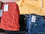 a box full of clothes that is sitting on a couch