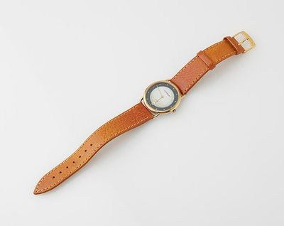 a close up of a watch on a white surface with a white background