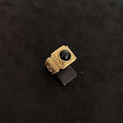 a close up of a black and gold ring on a black surface