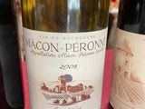 three bottles of wine sitting on a table with a red table cloth