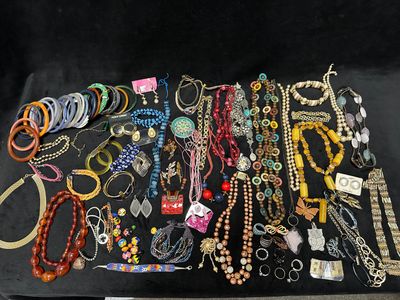 many different necklaces and bracelets laid out on a table