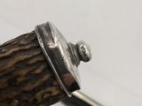 a close up of a silver object on top of a wooden stick