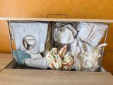 a metal basket filled with baby items on top of a wooden table