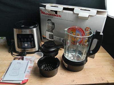 a blender sitting on top of a wooden table next to a box
