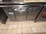 une cuisine équipée d'un plan de travail en inox et de deux fours