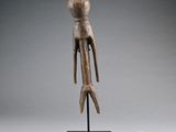 une sculpture en bois représentant un oiseau, posée sur un socle noir