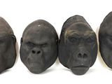 three different sized gorilla heads sitting next to each other on a white surface