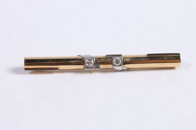a picture of a gold and diamond tie bar on a white background