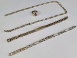 trois morceaux de chaîne en argent avec un fermoir, posés sur une surface blanche