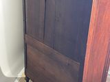 a tall wooden cabinet in the corner of a room