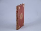 a small red book with a gold design on it