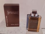 un flacon de parfum posé sur une table à côté d'une boîte
