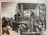 a black and white photo of an old car with people in the back