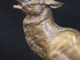 bronze sculpture of a stag with antlers on a black background
