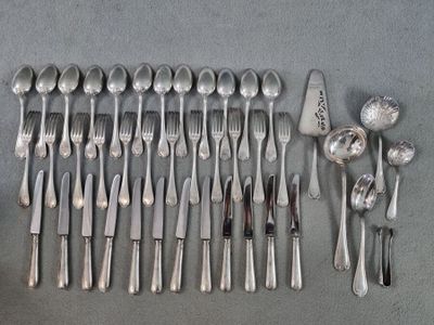 un grand nombre de cuillères et de fourchettes disposées sur la table