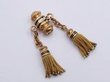 a close up of a pair of earrings with tassels on them