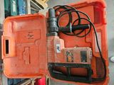 une boîte orange contenant une perceuse et un cordon d'alimentation