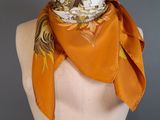 an orange scarf on a mannequin torso with a white mannequin behind it