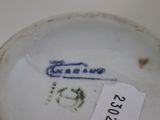 a close up of a white vase with a tag on it