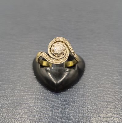 gros plan d'une bague en or avec un diamant au centre