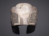 a close up of a silver bracelet on a black surface