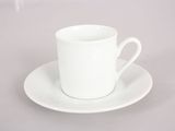 an empty cup and saucer on a white plate on a table