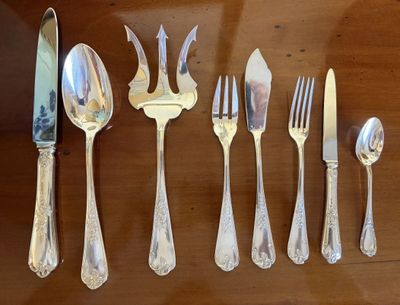 a lot of silverware on a table with a knife and fork