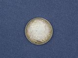 a close up of a silver coin on a blue cloth