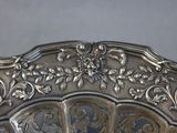 a silver plate that has a decorative design on it