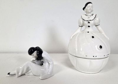porcelain figurines of a woman in a dress and a man in a tuxedo sitting next to each other
